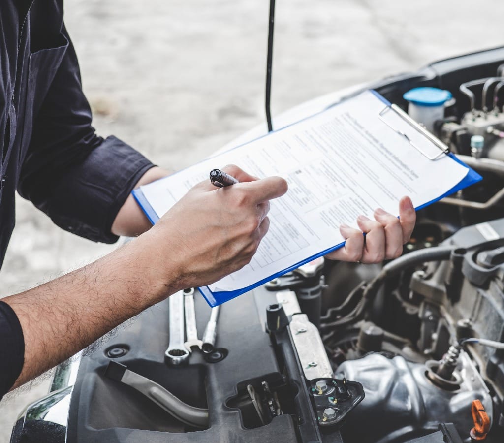 Services car engine machine concept, Automobile mechanic repairman checking a car engine with inspecting writing to the clipboard the checklist for repair machine, car service and maintenance